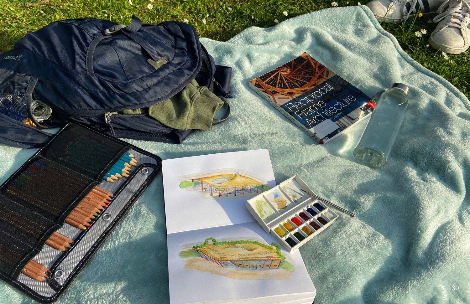 Sketchbook and watercolors on a blanket